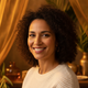 Close-up portrait of a smiling woman, mid-30s, conveying trust and satisfaction.